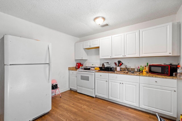 kitchen featuring white cabinetry, light hardwood / wood-style floors, and white appliances