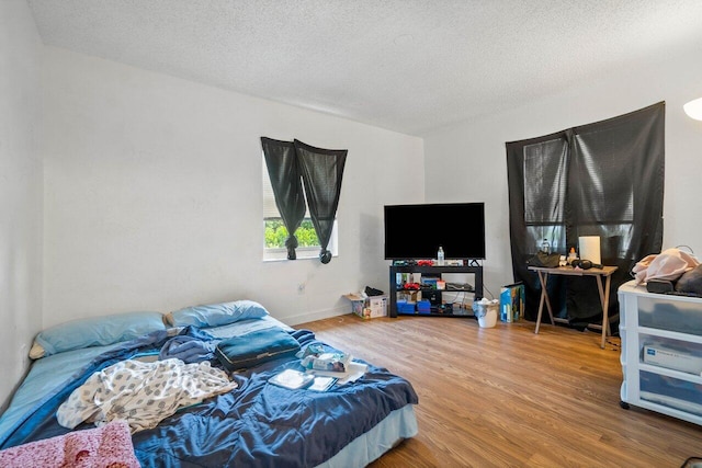 bedroom with hardwood / wood-style flooring and a textured ceiling