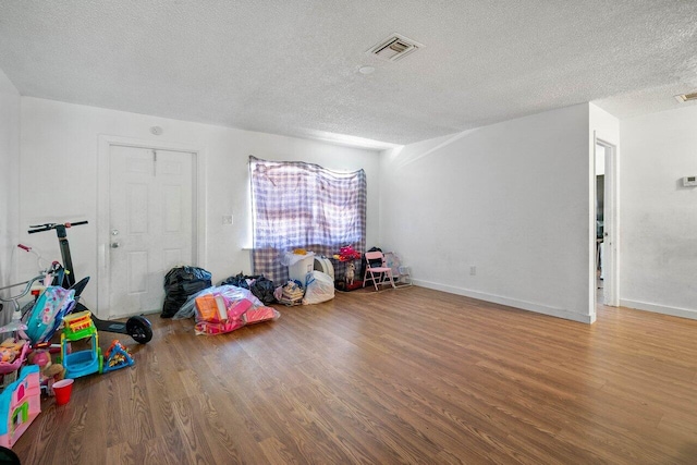 rec room with hardwood / wood-style flooring and a textured ceiling