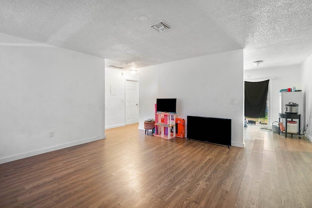 playroom featuring hardwood / wood-style flooring and a textured ceiling