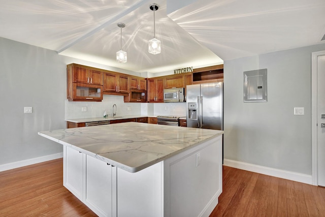 kitchen with a center island, stainless steel appliances, electric panel, and sink