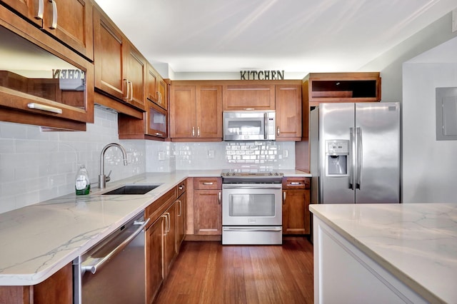 kitchen featuring stainless steel appliances, tasteful backsplash, sink, and light stone counters