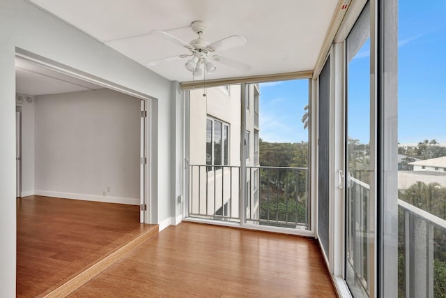 unfurnished sunroom featuring ceiling fan and a healthy amount of sunlight