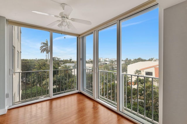 unfurnished sunroom featuring ceiling fan