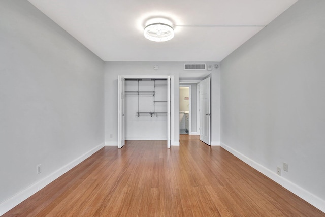 unfurnished bedroom featuring light hardwood / wood-style floors and a closet