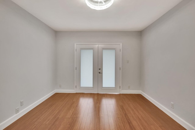 spare room featuring hardwood / wood-style flooring and french doors