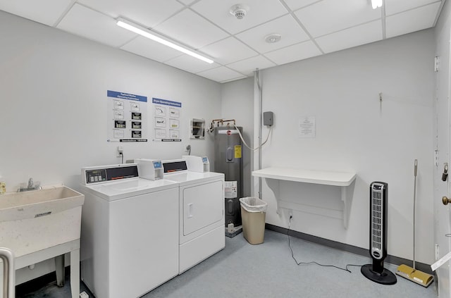 washroom with washing machine and clothes dryer, sink, and water heater