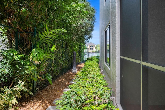 view of side of home with fence and stucco siding