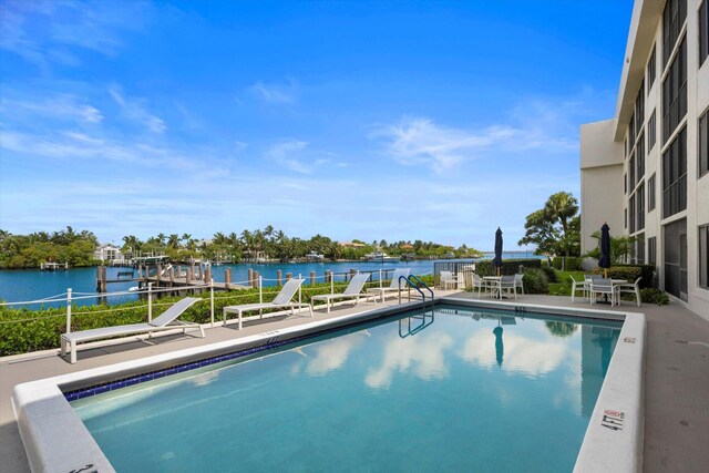 view of pool with a patio and a water view