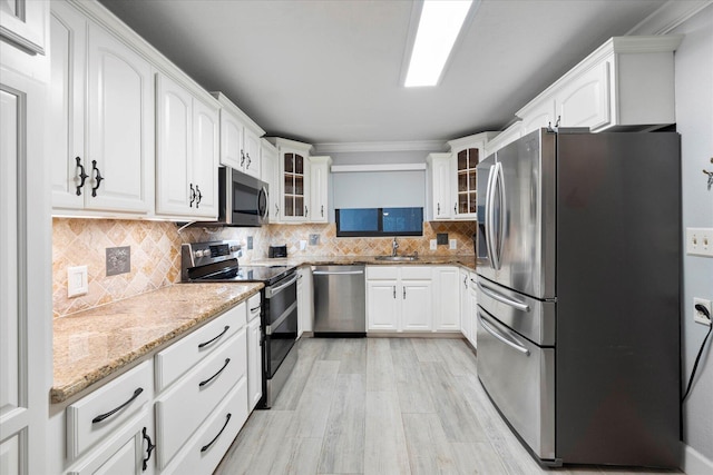 kitchen featuring stainless steel appliances, decorative backsplash, glass insert cabinets, and white cabinets