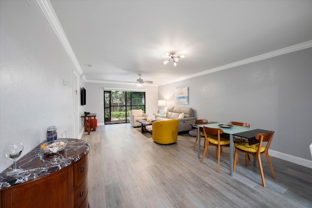 living room with light wood-style floors, baseboards, ornamental molding, and ceiling fan