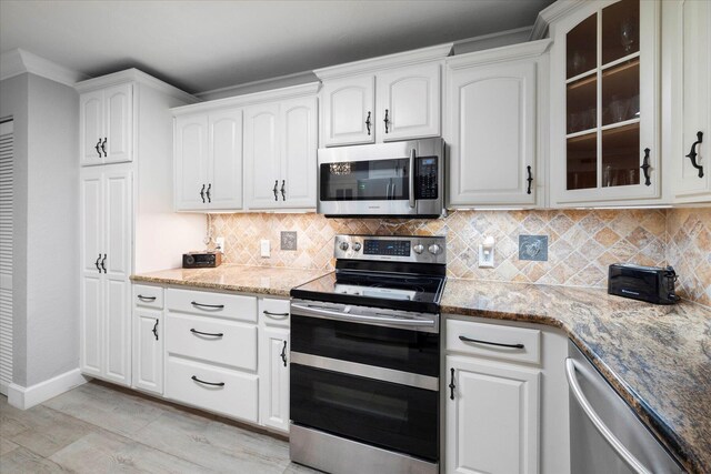 kitchen featuring white cabinetry, light stone countertops, backsplash, and stainless steel appliances