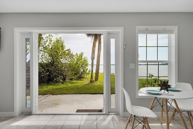 doorway to outside featuring light tile patterned flooring and a water view