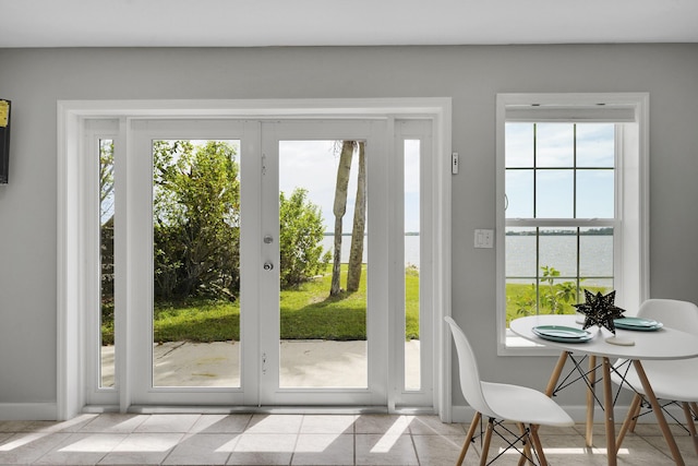 doorway with a water view and light tile patterned floors