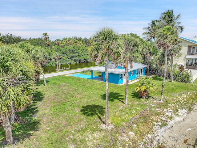 view of swimming pool featuring a water view and a lawn