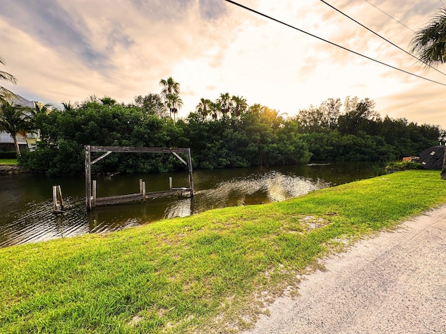 dock area with a lawn and a water view