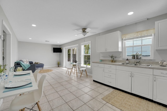 kitchen featuring white cabinetry, ceiling fan, and sink