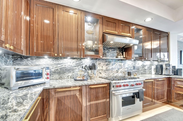 kitchen with decorative backsplash, designer range, and light stone counters