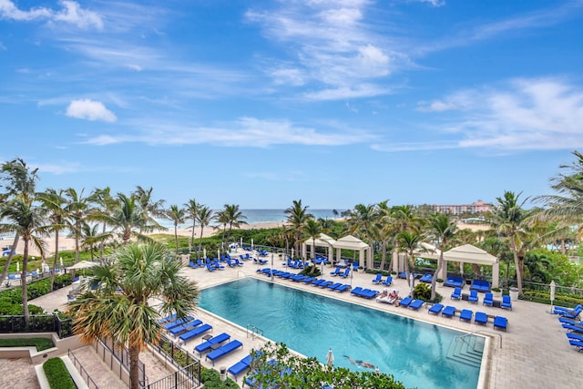 view of swimming pool with a water view and a patio