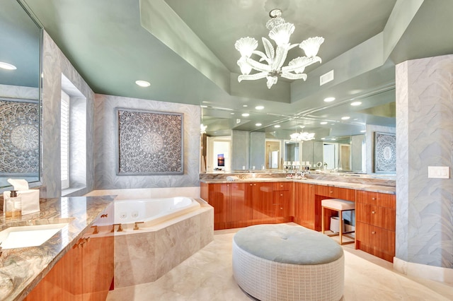 bathroom with a notable chandelier, vanity, a relaxing tiled tub, and tile walls