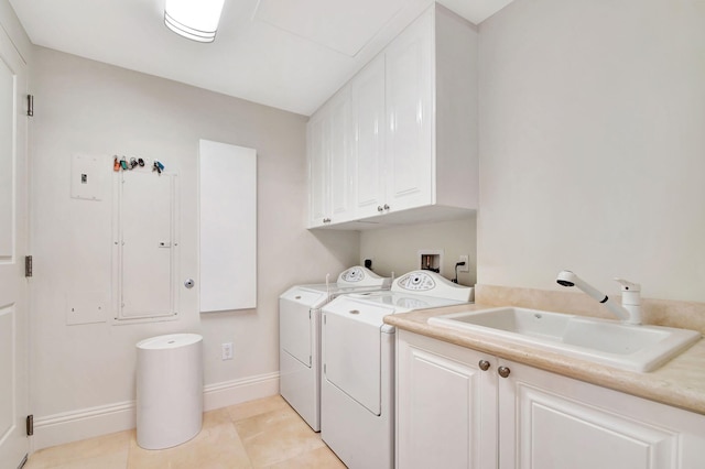 washroom with cabinets, light tile patterned floors, washer and dryer, and sink