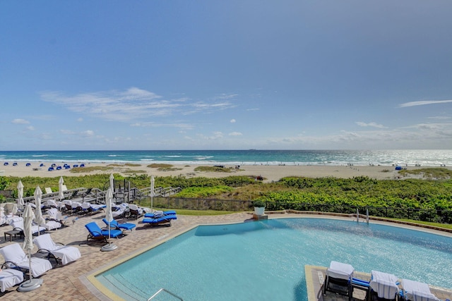 view of swimming pool with a view of the beach and a water view