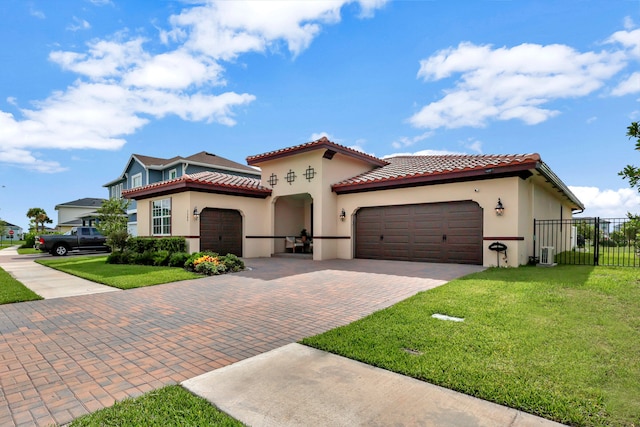 mediterranean / spanish-style house featuring a garage, cooling unit, and a front yard