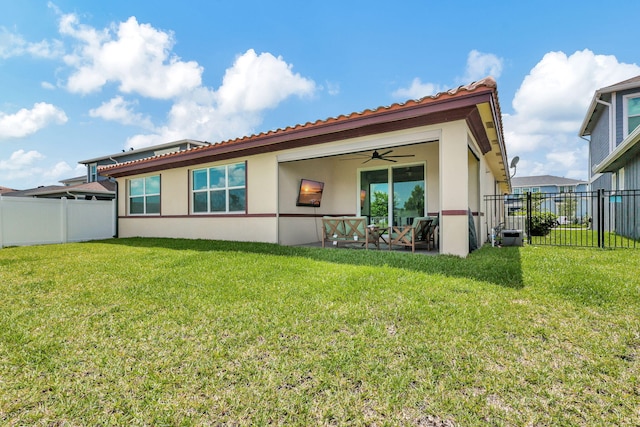 rear view of house featuring a lawn, ceiling fan, and a patio area