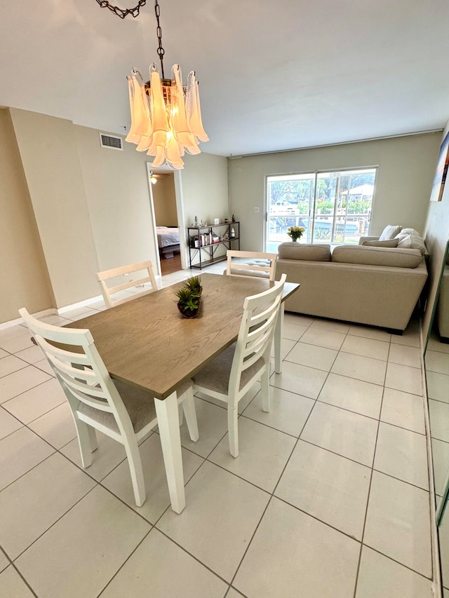 dining room featuring a chandelier and light tile patterned flooring