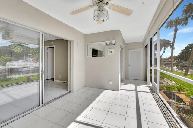 unfurnished sunroom featuring ceiling fan