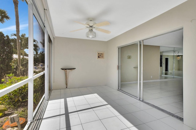 unfurnished sunroom with ceiling fan