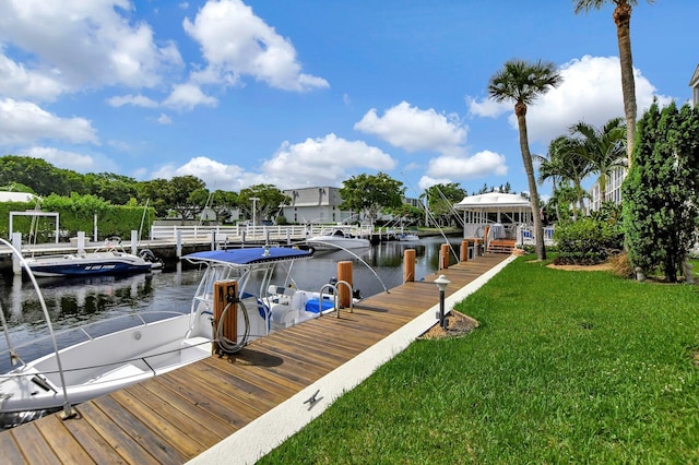 view of dock with a yard and a water view