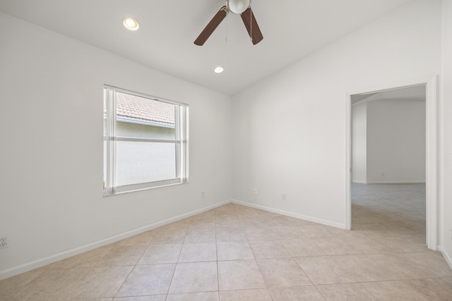 tiled empty room featuring ceiling fan and vaulted ceiling