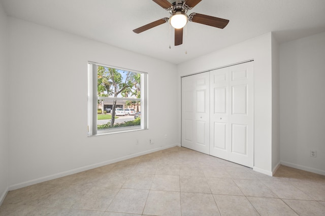 unfurnished bedroom featuring light tile patterned floors, a closet, and ceiling fan