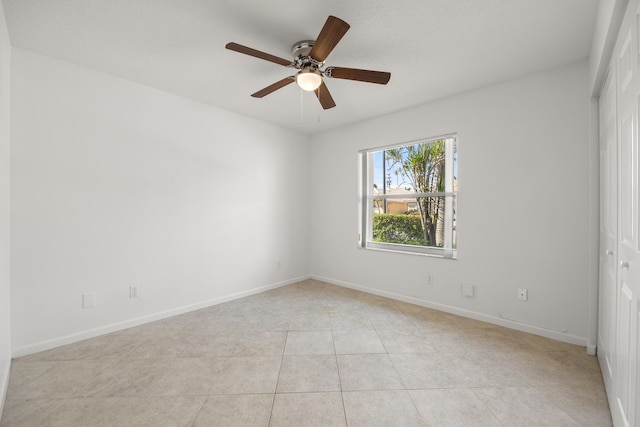 tiled spare room featuring ceiling fan