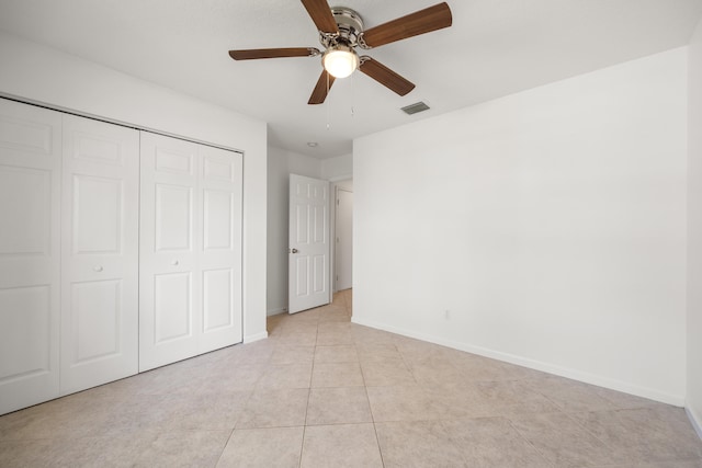 unfurnished bedroom with light tile patterned floors, a closet, and ceiling fan