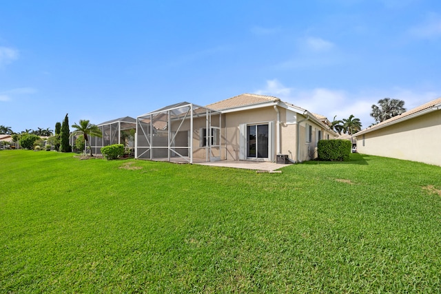 back of property with a patio area, a lanai, and a lawn