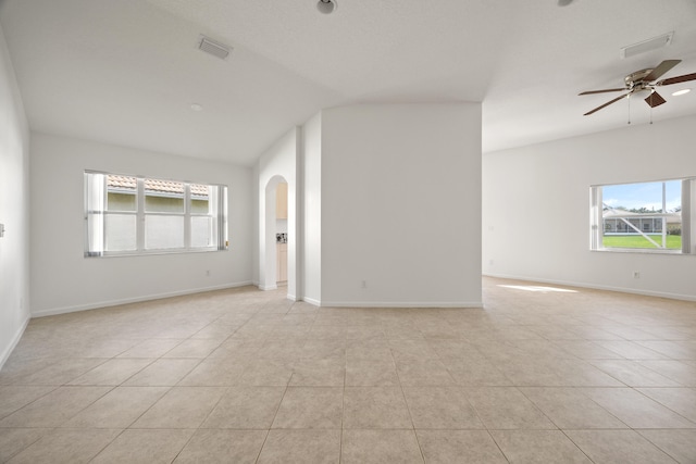 tiled spare room featuring ceiling fan and vaulted ceiling