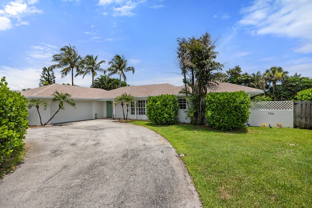 single story home with a garage and a front yard