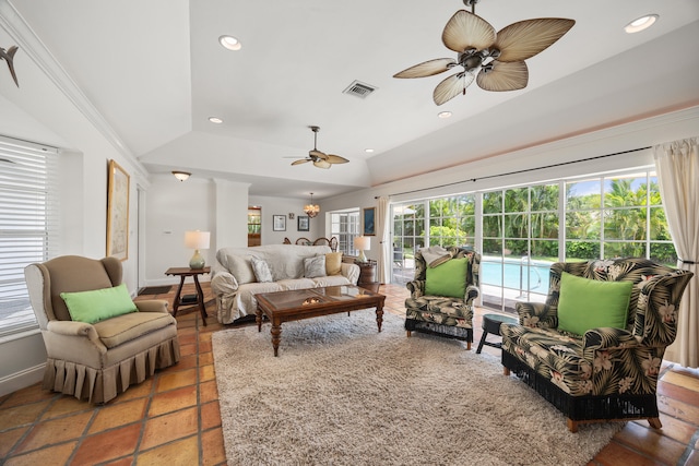 living room with tile floors, ornamental molding, ceiling fan, and vaulted ceiling