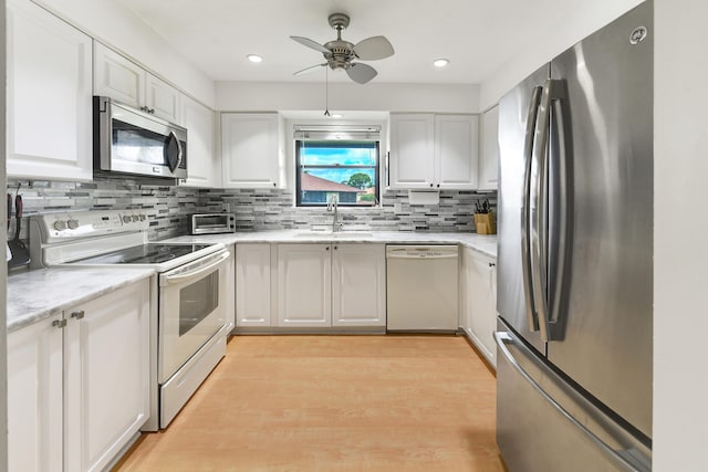 kitchen featuring white cabinets, appliances with stainless steel finishes, tasteful backsplash, and sink