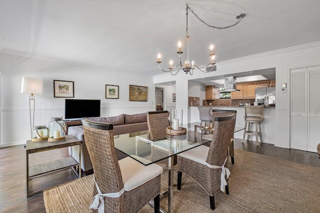 dining space with hardwood / wood-style flooring, an inviting chandelier, and ornamental molding