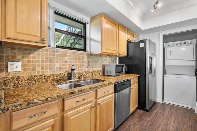 kitchen featuring sink, stacked washing maching and dryer, dark hardwood / wood-style flooring, light stone counters, and stainless steel appliances