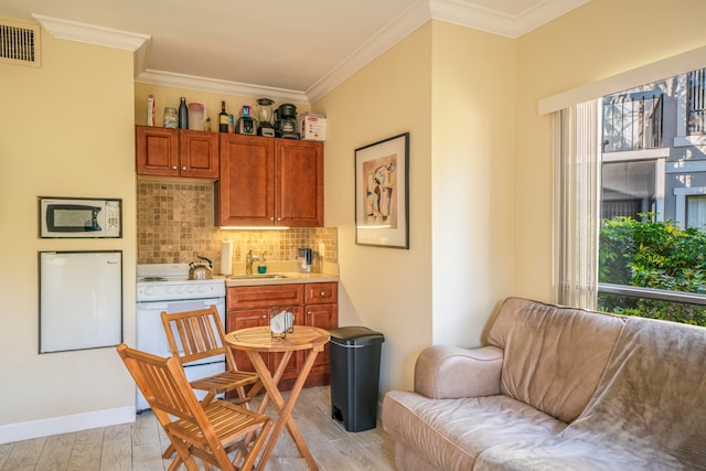 interior space with white appliances, light hardwood / wood-style floors, plenty of natural light, and ornamental molding