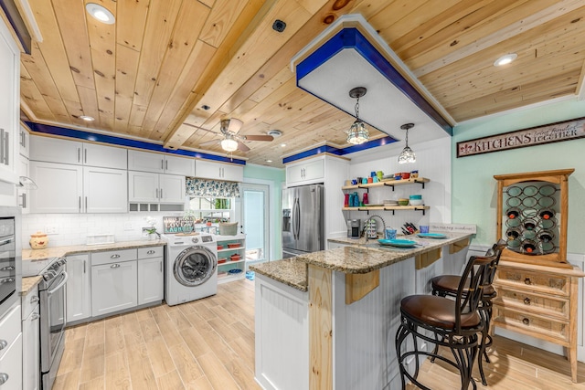 kitchen with white cabinets, appliances with stainless steel finishes, wood ceiling, and washer / dryer