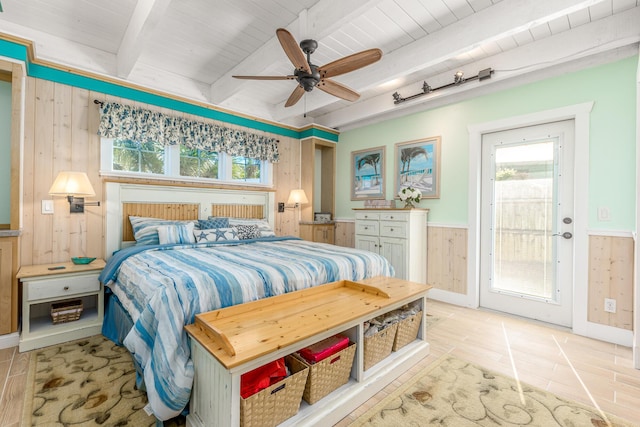 tiled bedroom with beamed ceiling, wooden walls, access to outside, ceiling fan, and wooden ceiling