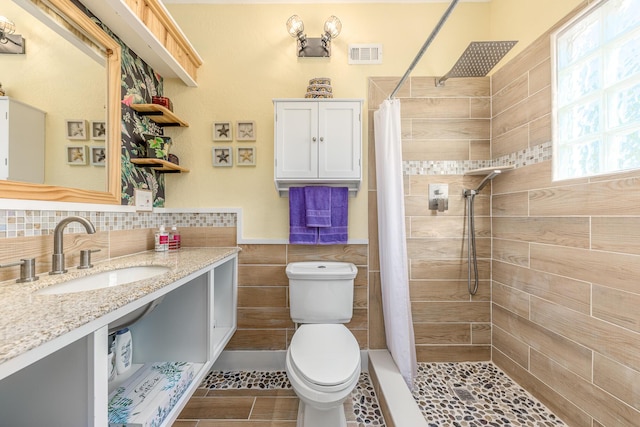 bathroom with curtained shower, toilet, and vanity