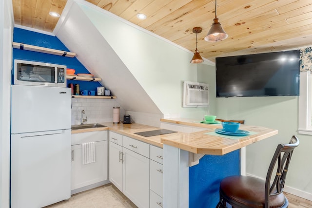 kitchen with butcher block counters, wooden ceiling, hanging light fixtures, white refrigerator, and white cabinets