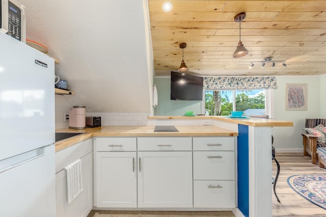 kitchen with decorative backsplash, white cabinetry, hanging light fixtures, wood ceiling, and white refrigerator