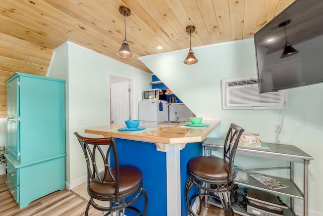 kitchen featuring decorative light fixtures, a kitchen bar, sink, wood ceiling, and butcher block counters